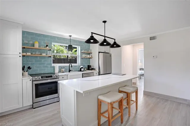 a kitchen with stainless steel appliances a stove a sink and a refrigerator