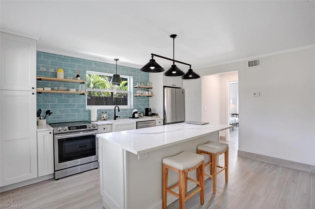 982 13th Street North Naples, FL 34102 - Photo 6 of 29 a kitchen with stainless steel appliances a stove a sink and a refrigerator