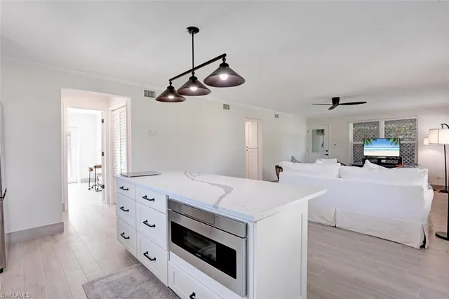 a view of a hallway that has a bed and a chandelier