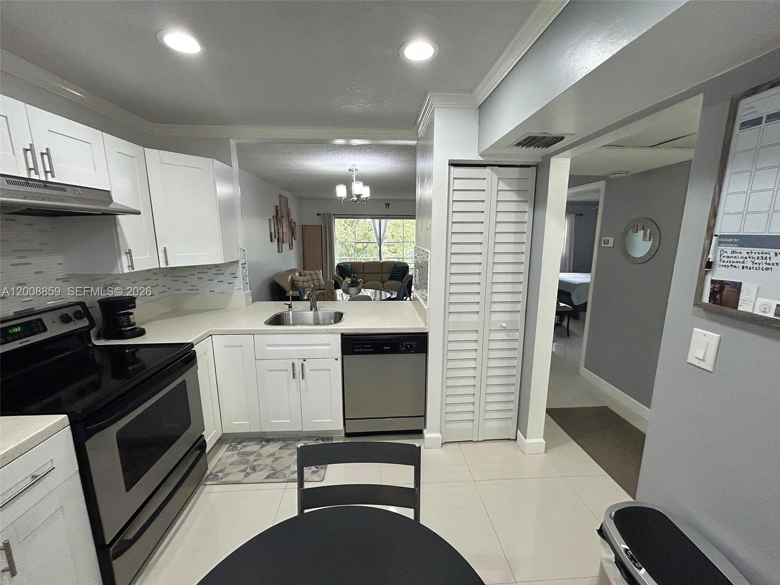 8818 West McNab Road, Unit 303 Tamarac, FL 33321 - Photo 12 of 32 a kitchen with a sink a stove and cabinets
