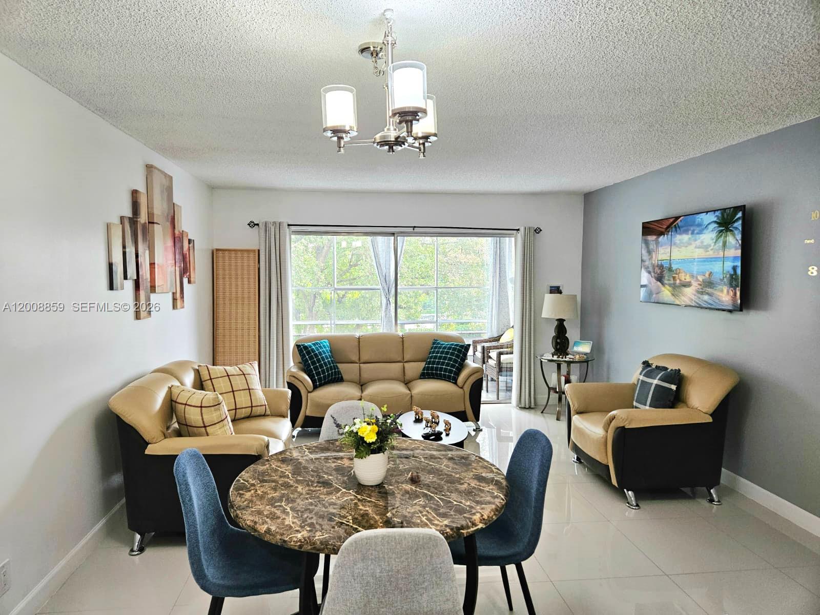 8818 West McNab Road, Unit 303 Tamarac, FL 33321 - Photo 4 of 32 a living room with furniture and a chandelier