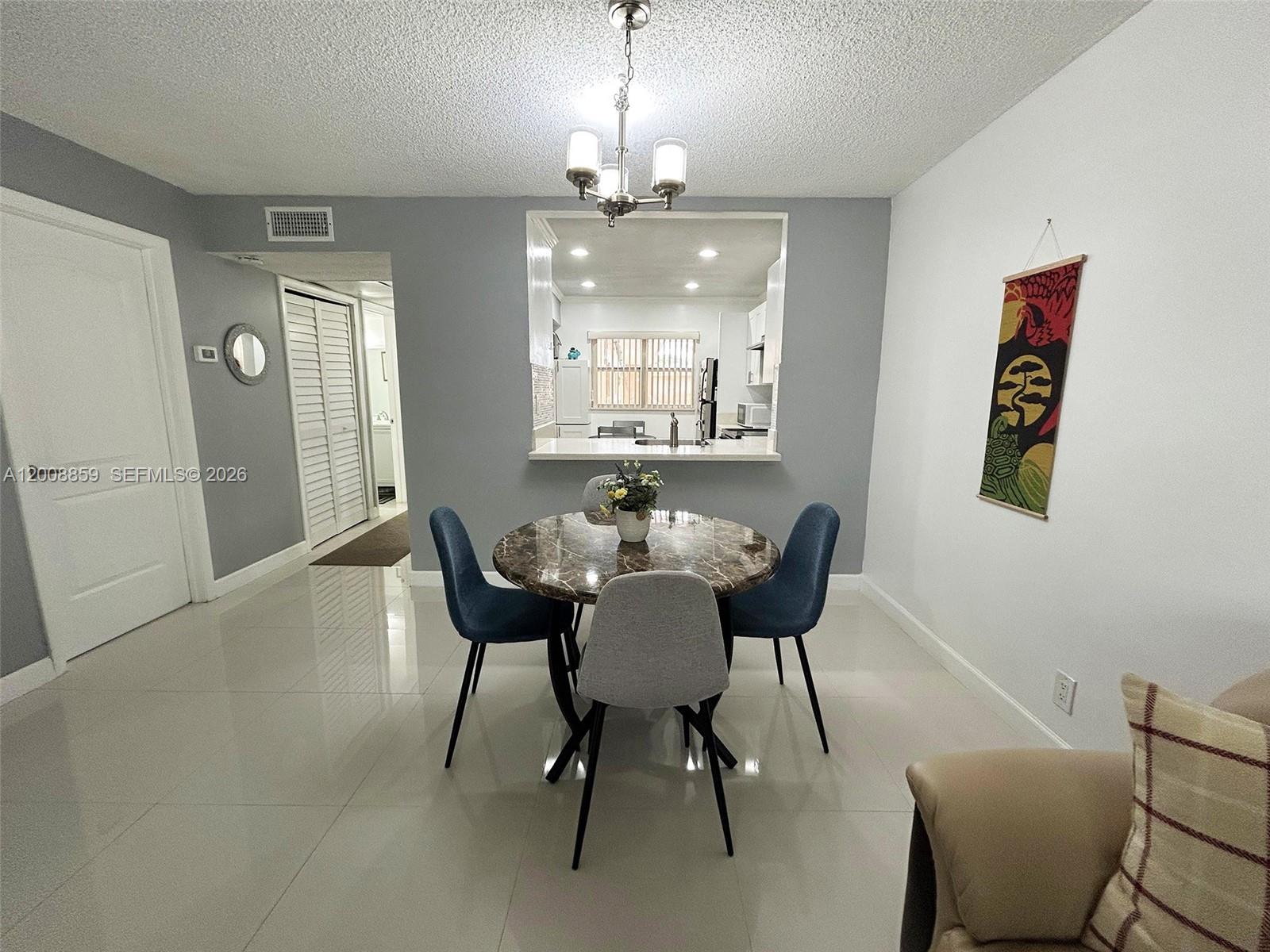 8818 West McNab Road, Unit 303 Tamarac, FL 33321 - Photo 8 of 32 a view of a dining room with furniture and chandelier