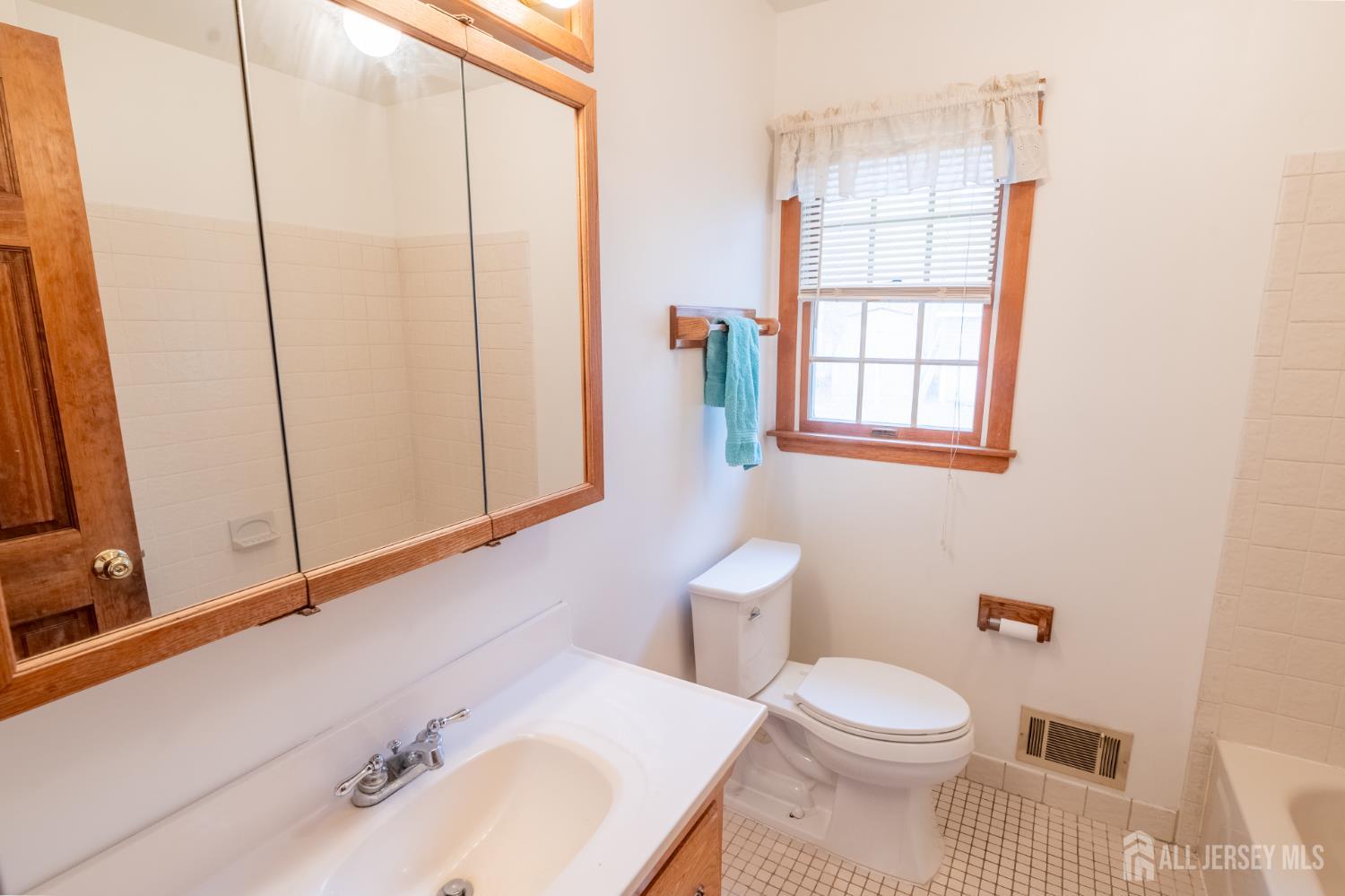 12 Francis Road East Brunswick, NJ 08816 - Photo 20 of 66 a bathroom with a sink a toilet and shower curtain