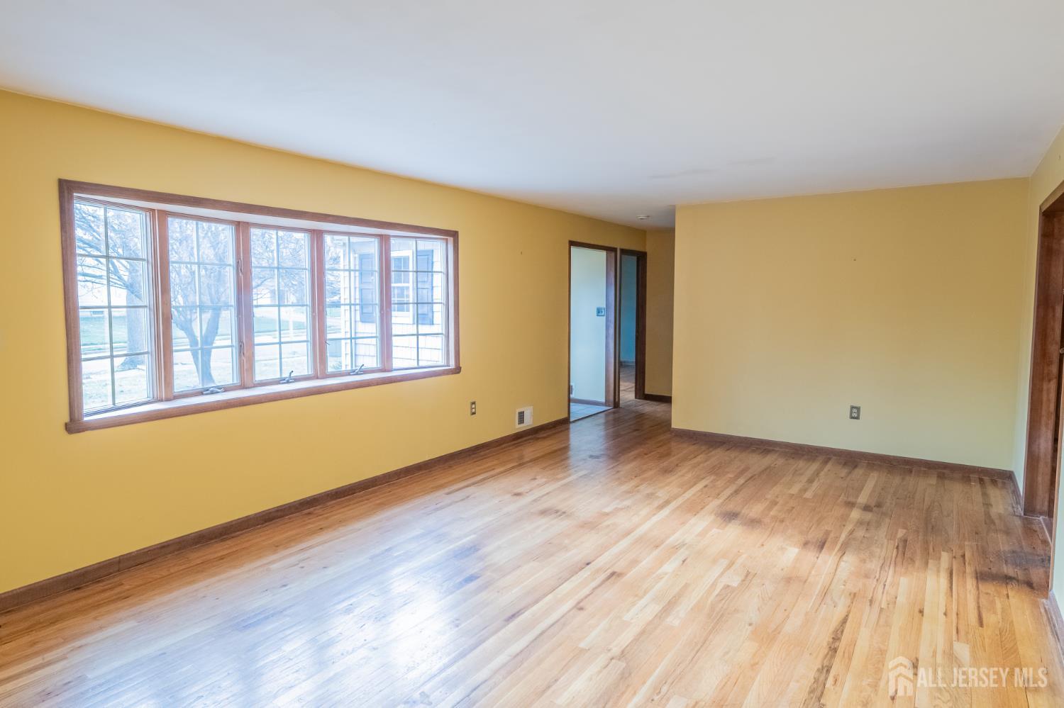 12 Francis Road East Brunswick, NJ 08816 - Photo 2 of 66 a view of an empty room with wooden floor and a window