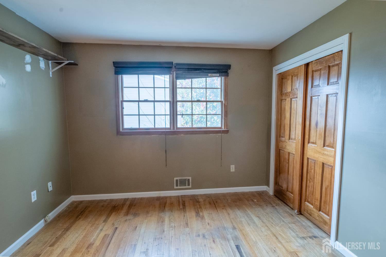 12 Francis Road East Brunswick, NJ 08816 - Photo 30 of 66 a view of an empty room with wooden floor and a window