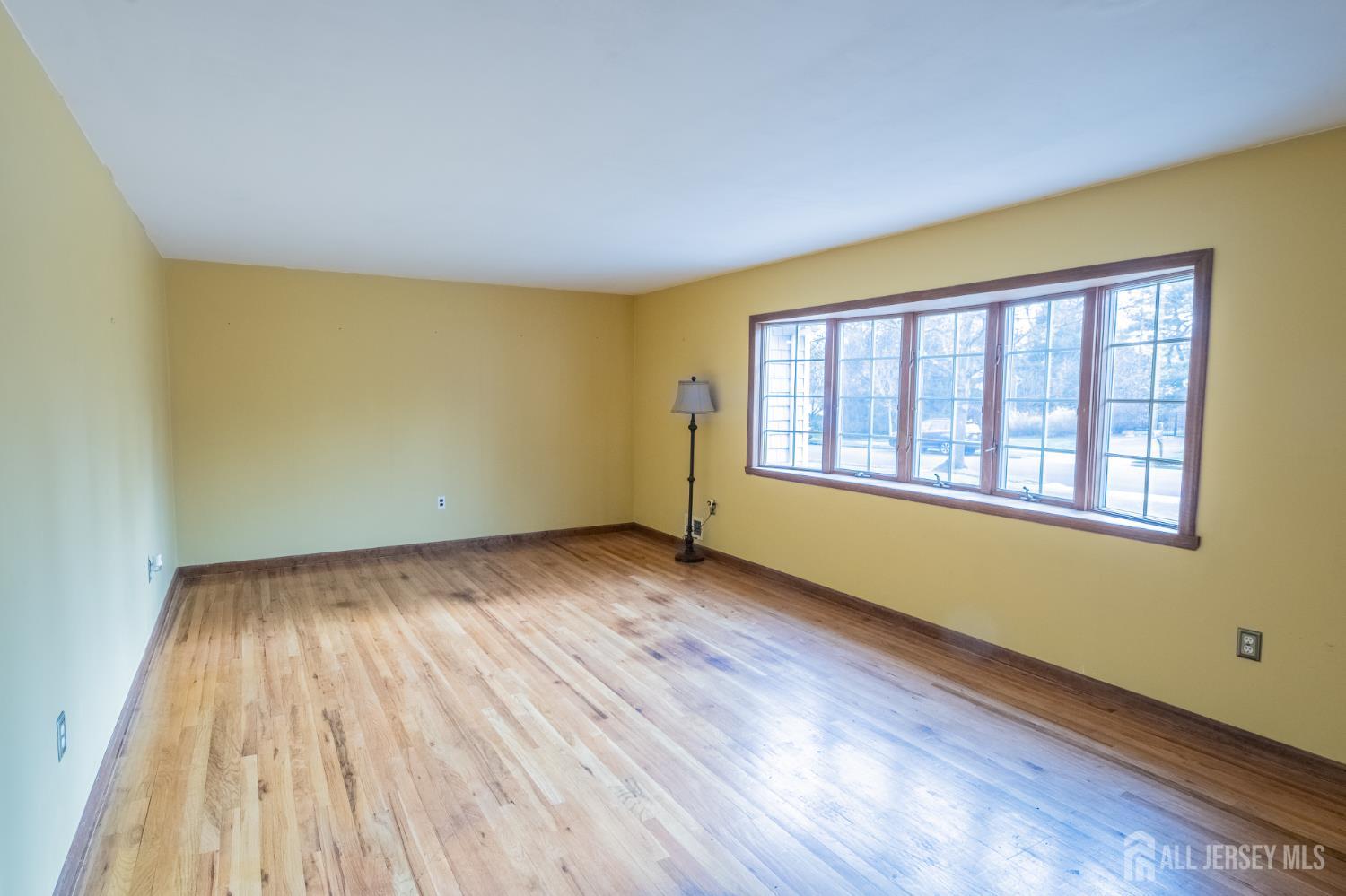12 Francis Road East Brunswick, NJ 08816 - Photo 4 of 66 a view of an empty room with wooden floor and a window