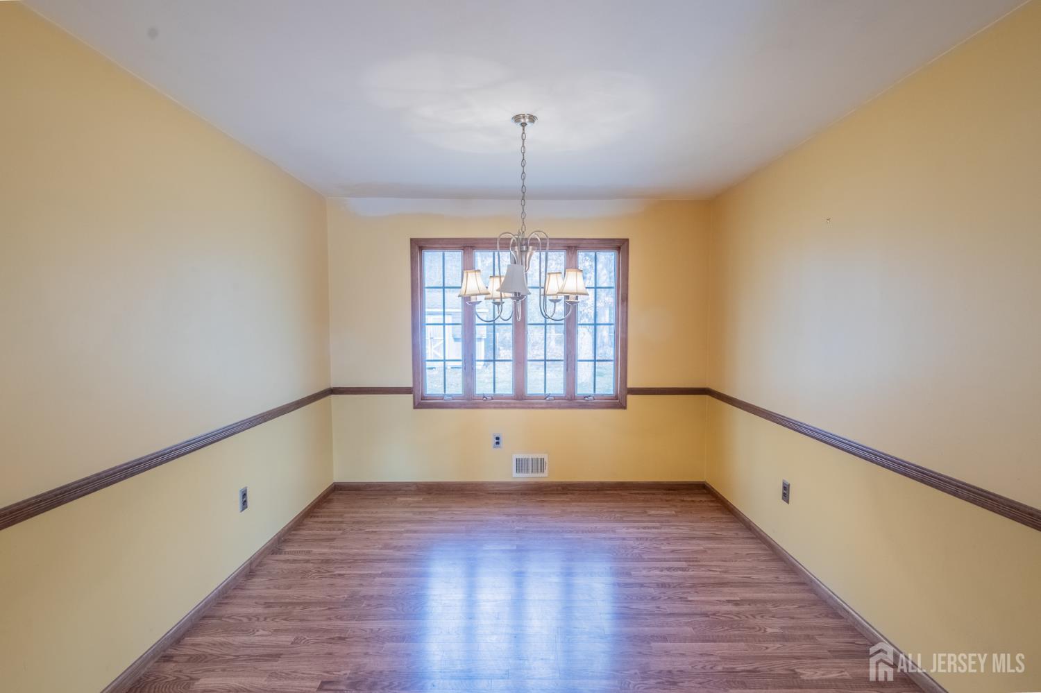 12 Francis Road East Brunswick, NJ 08816 - Photo 6 of 66 a view of an empty room with wooden floor and a window