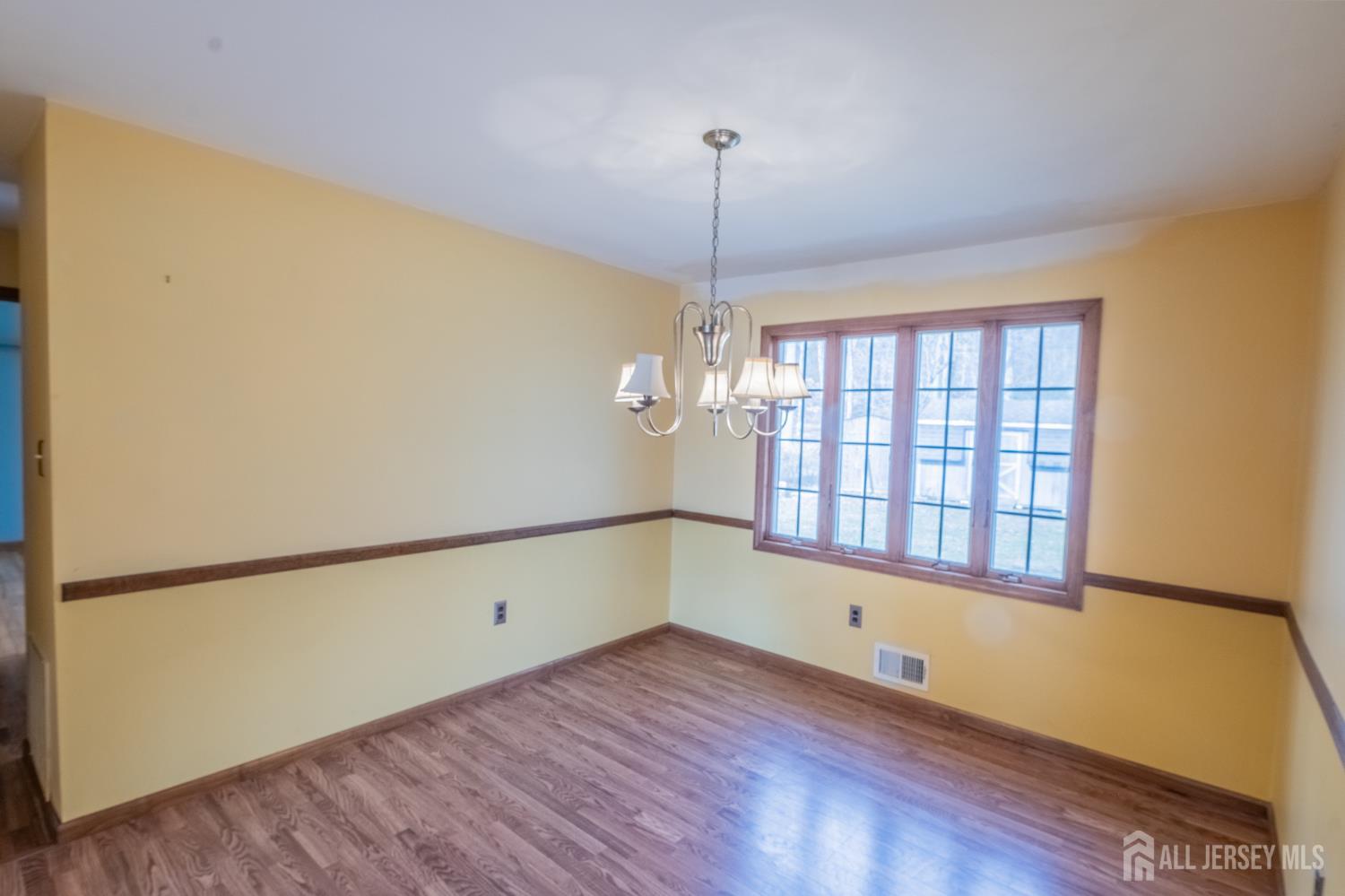 12 Francis Road East Brunswick, NJ 08816 - Photo 8 of 66 a view of an empty room with a window and wooden floor