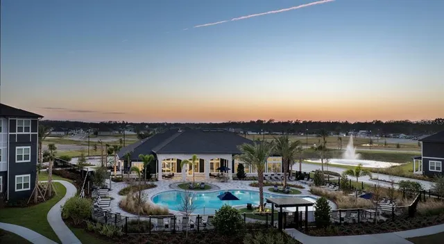 a view of a house with pool and chairs