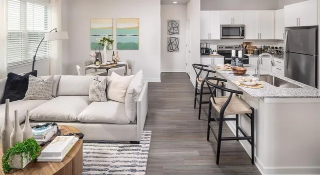 a living room with furniture a dining table and a refrigerator