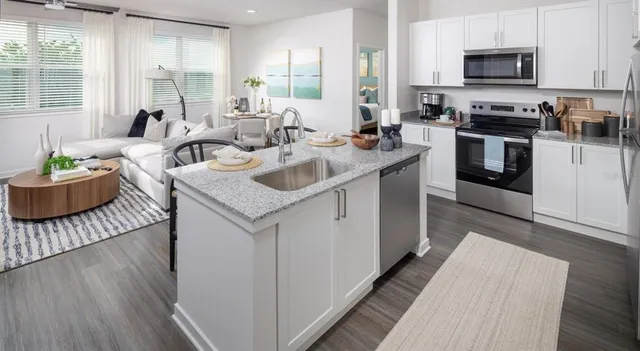 a kitchen with stainless steel appliances granite countertop a sink stove and wooden floor