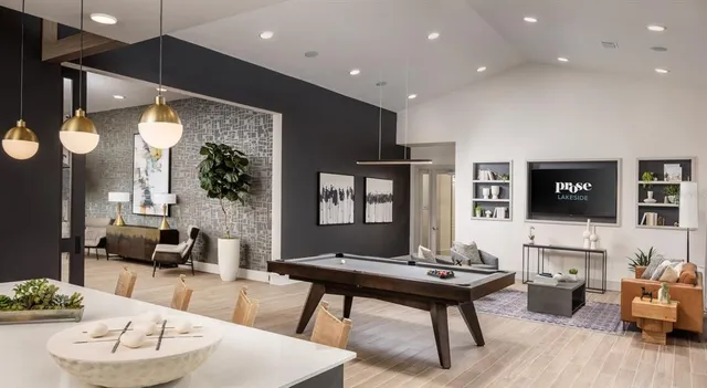 a living room with furniture a flat screen tv and a table