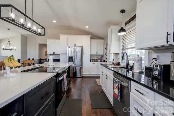 a kitchen with stainless steel appliances sink stove refrigerator and cabinets