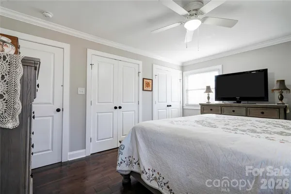a bedroom with a bed and a flat tv screen on wall