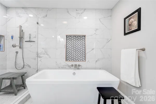 a bath tub sitting next to a white sink and a shower