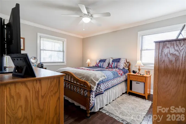 a bedroom with a bed and a flat tv screen on the dresser