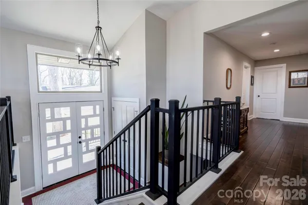 a view of a hallway with wooden floor and windows