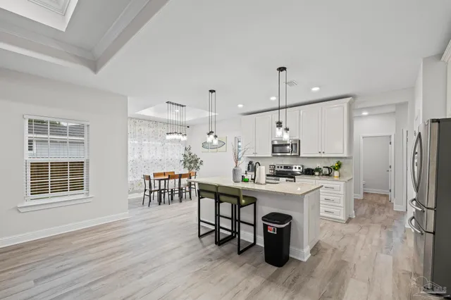 a kitchen with a dining table chairs stove refrigerator and cabinets