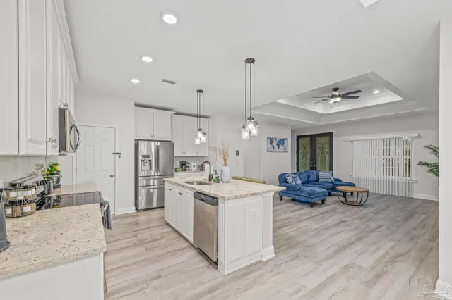 a open kitchen with stainless steel appliances granite countertop a stove oven and a fireplace with cabinets