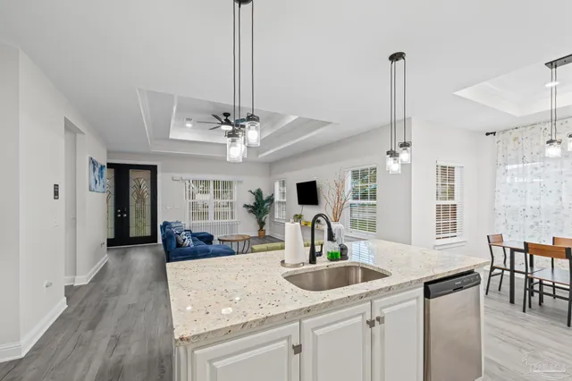 a kitchen with stainless steel appliances granite countertop a sink a stove and a refrigerator