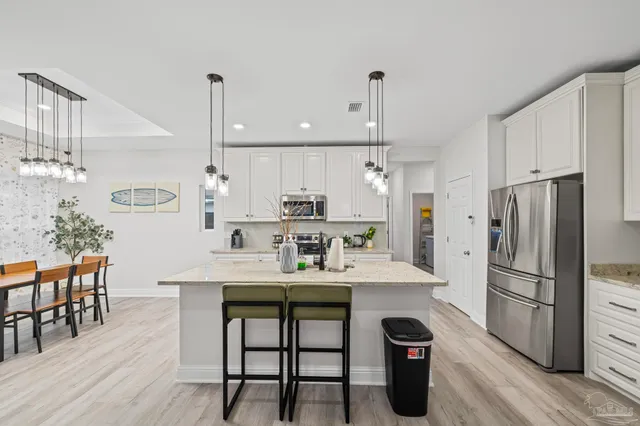 a kitchen with stainless steel appliances white cabinets and a refrigerator