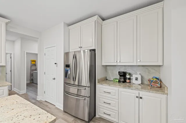 a kitchen with stainless steel appliances kitchen island granite countertop a sink a stove and chairs