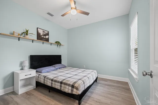 a bedroom with a bed and wooden floor