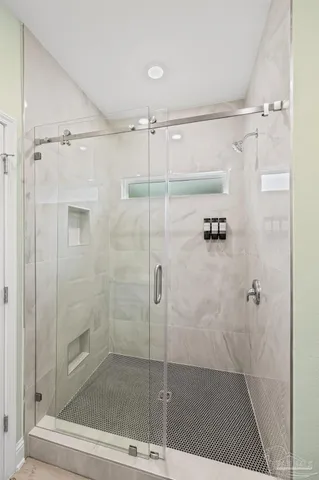 a spacious bedroom with a large bed and a chandelier