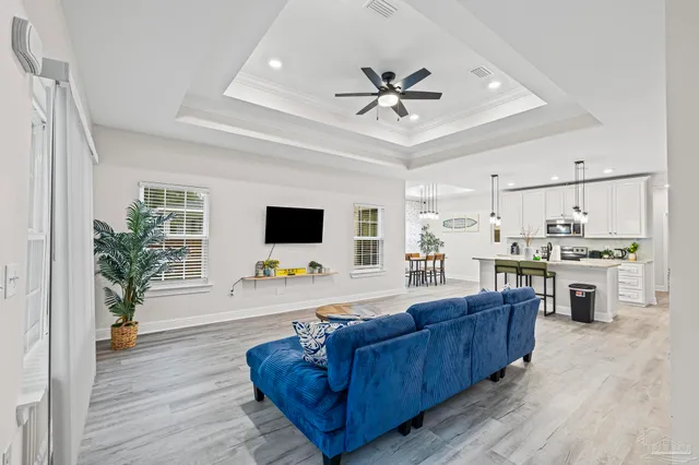 a living room with kitchen island furniture and a ceiling fan