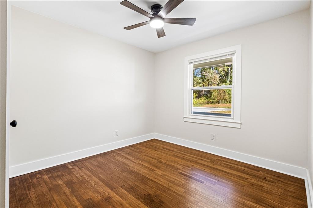 4976 Mable Lake Drive Southwest Mableton, GA 30126 - Photo 12 of 18 an empty room with wooden floor ceiling fan and windows