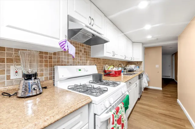 a kitchen that has a stove and a wooden floor