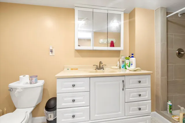 a bathroom with a granite countertop toilet sink and mirror