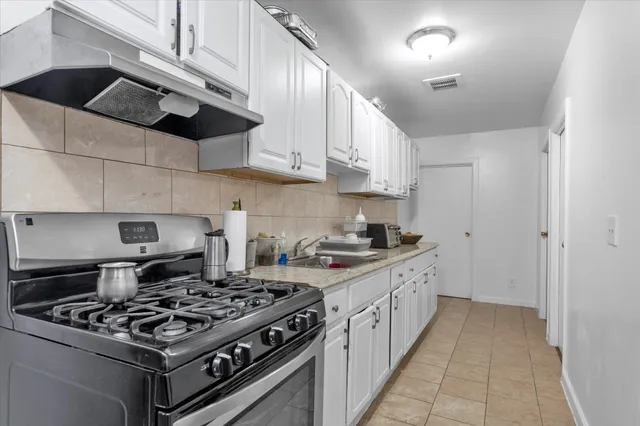a kitchen with stainless steel appliances a sink stove and cabinets