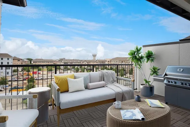 a roof deck with couches and potted plants