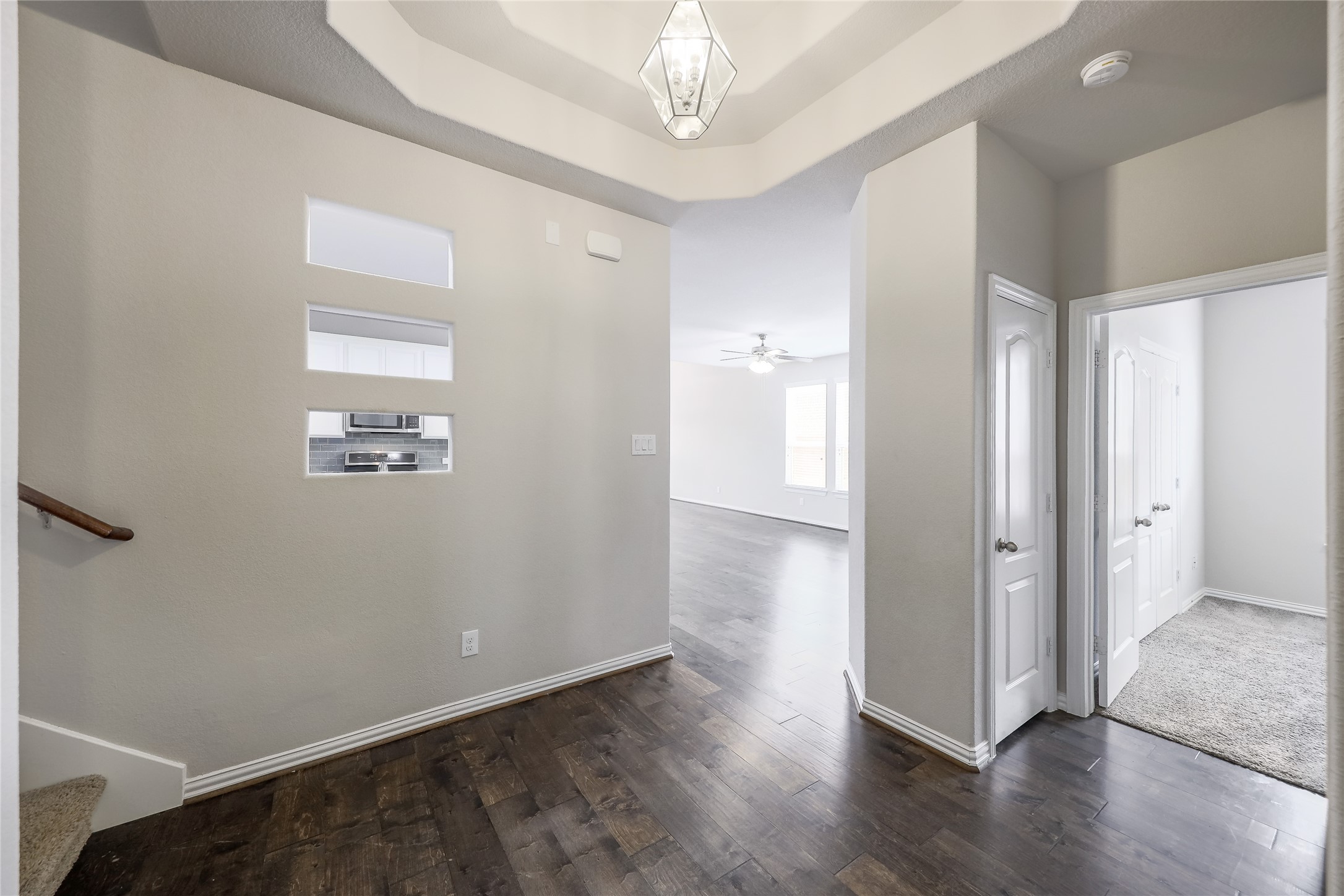 205 Penna Lane Georgetown, TX 78628 - Photo 12 of 32 Rich hardwood flooring leads to an inviting open concept living space, anchored by a stylish overhead light fixture.