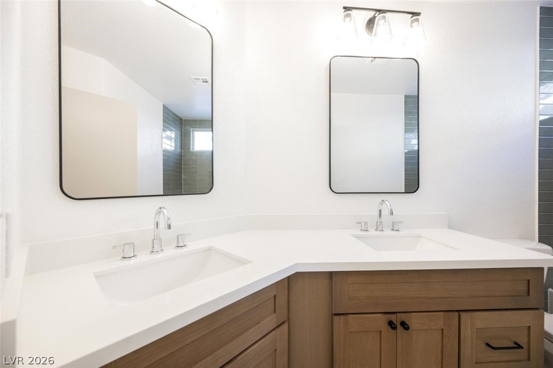 2651 Ridgewater Circle Henderson, NV 89074 - Photo 21 of 27 This bright bathroom features dual vanities and modern mirrors.
