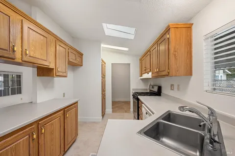 a kitchen that has a sink cabinets counter space and appliances