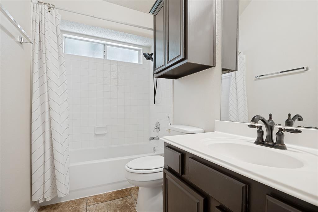 2100 Los Rios Boulevard Plano, TX 75074 - Photo 19 of 25 Bathroom vanity featuring a white countertop with integrated sink and dark wood-finish cabinetry