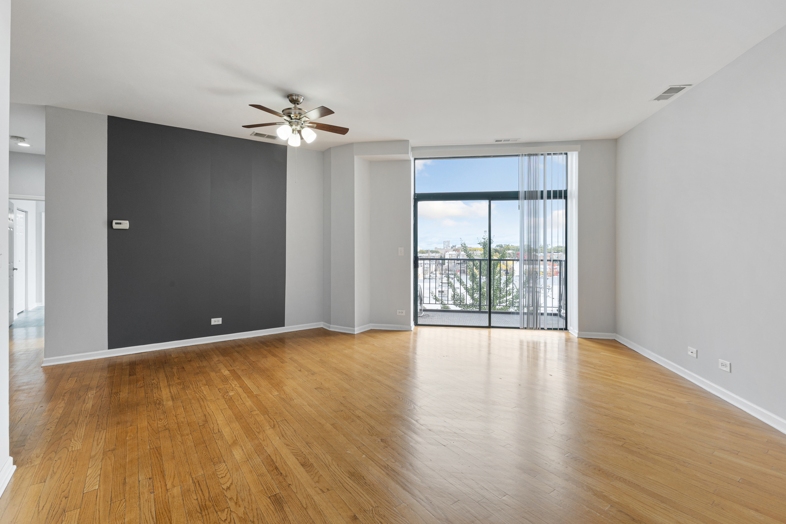 2451 West Howard Street, Unit 406 Chicago, IL 60645 - Photo 2 of 15 a view of an empty room with a window and wooden floor