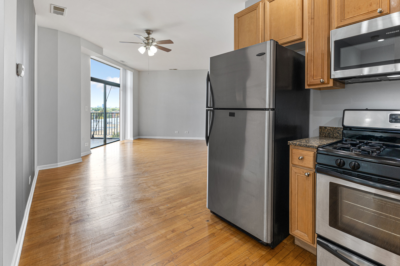 2451 West Howard Street, Unit 406 Chicago, IL 60645 - Photo 3 of 15 a kitchen with stainless steel appliances granite countertop a refrigerator microwave and sink