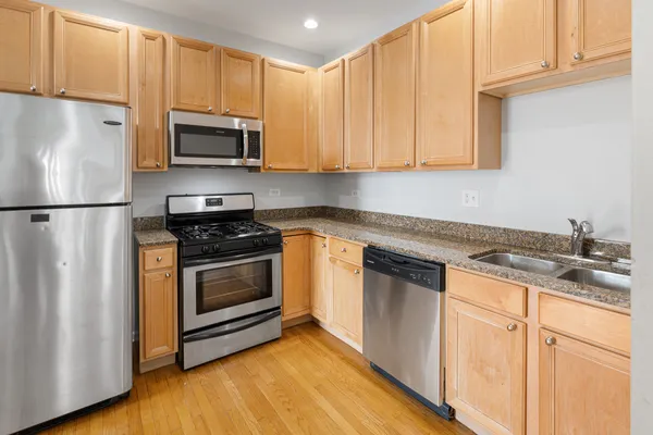 a kitchen with granite countertop white cabinets and white appliances