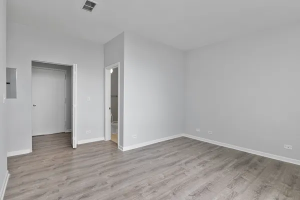 a view of an empty room with wooden floor