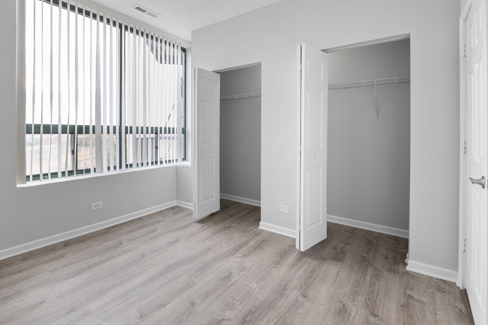 2451 West Howard Street, Unit 406 Chicago, IL 60645 - Photo 9 of 15 an empty room with wooden floor and windows