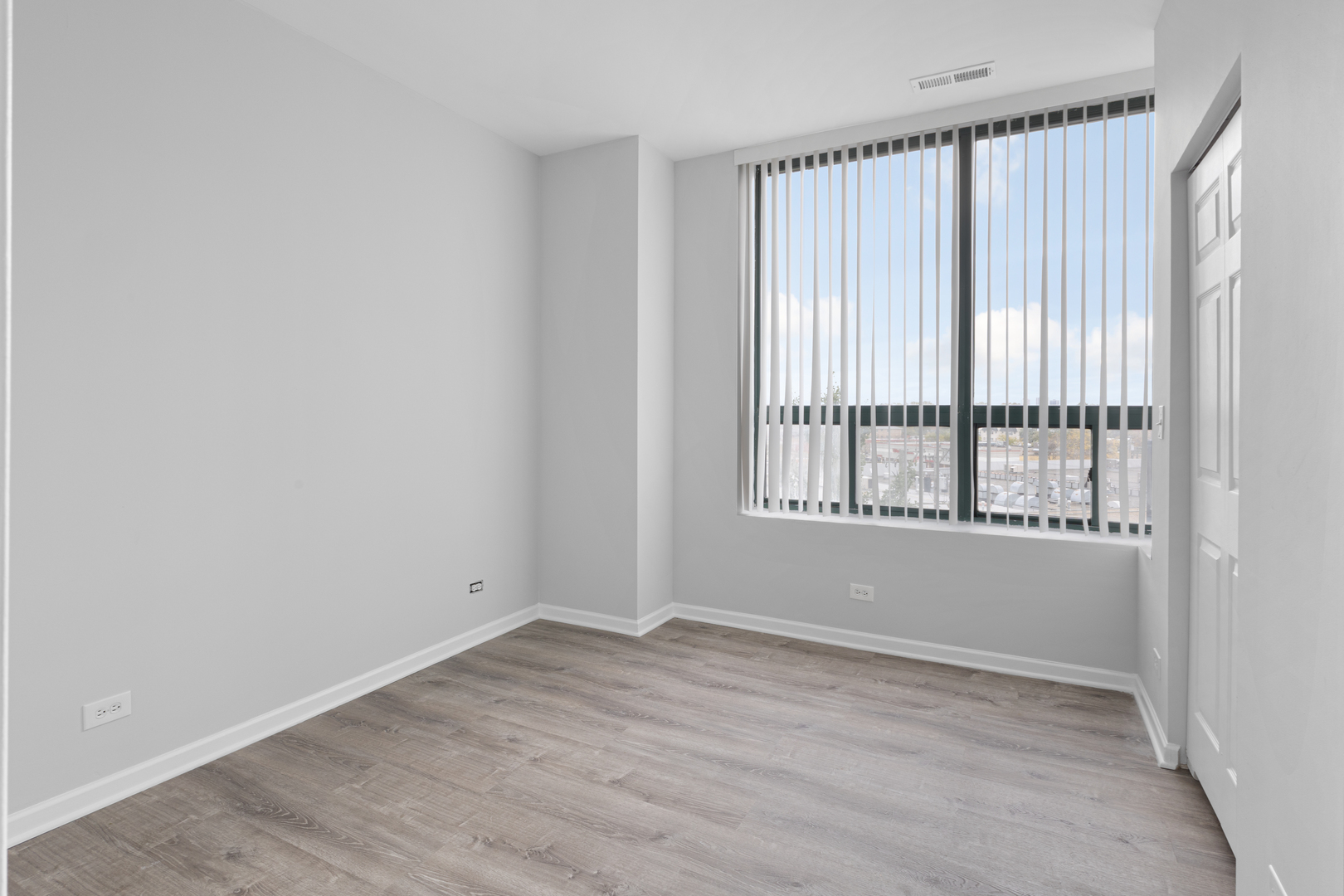2451 West Howard Street, Unit 406 Chicago, IL 60645 - Photo 10 of 15 wooden floor in an empty room with a window