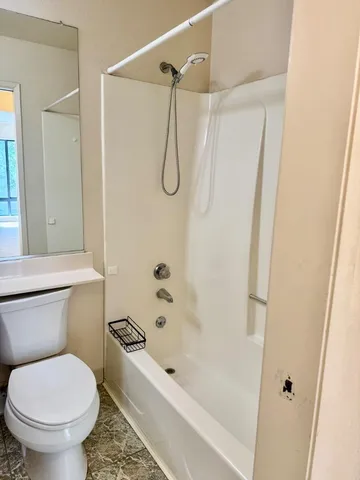 a bathroom with a toilet and a shower