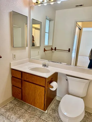 a bathroom with a toilet sink and mirror