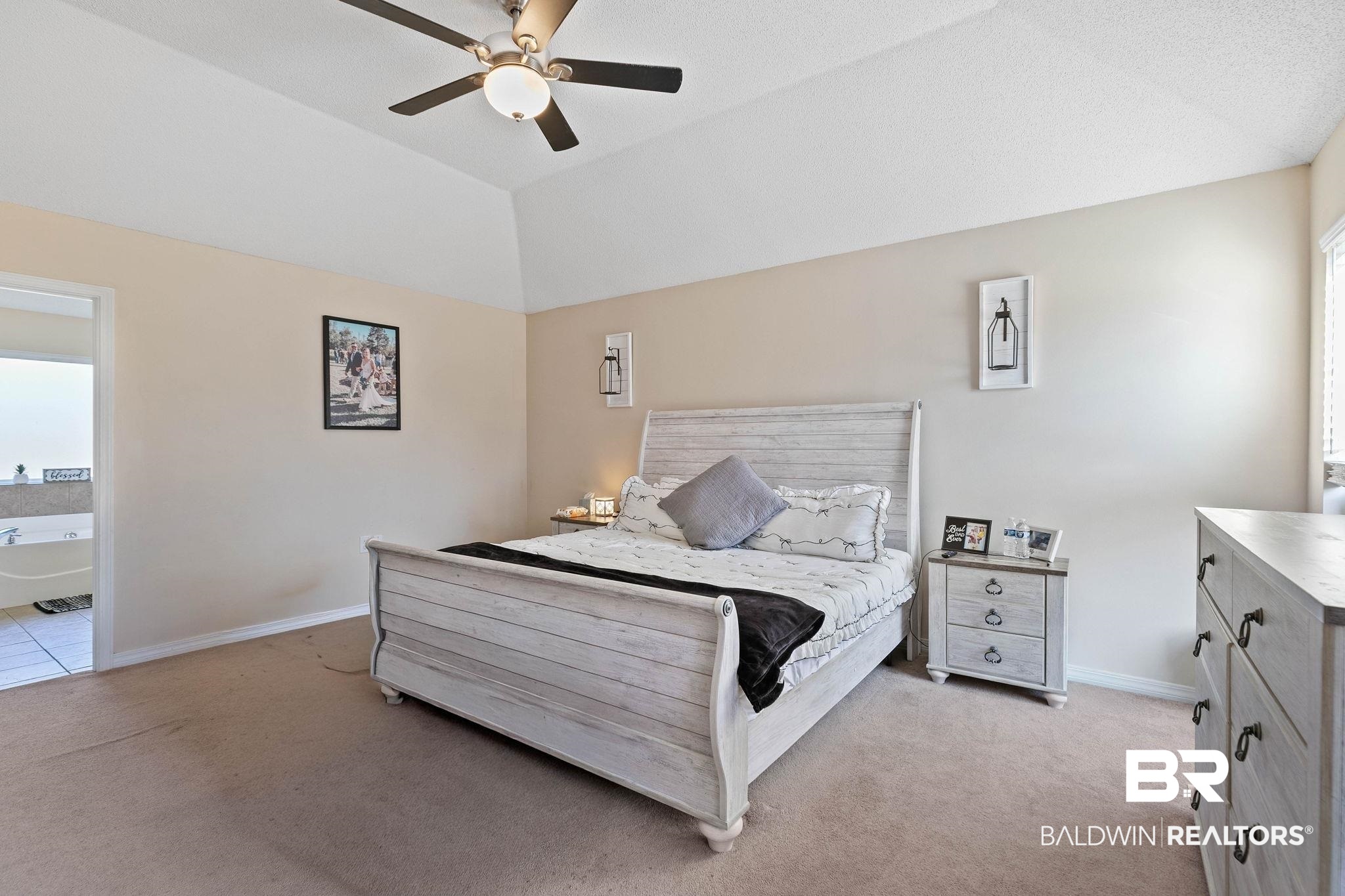 55750 Lottie Road Perdido, AL 36562 - Photo 56 of 84 Bedroom featuring light carpet, ceiling fan, vaulted ceiling, and connected bathroom