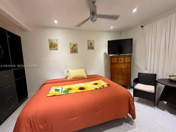 a bedroom with a bed and a flat screen tv