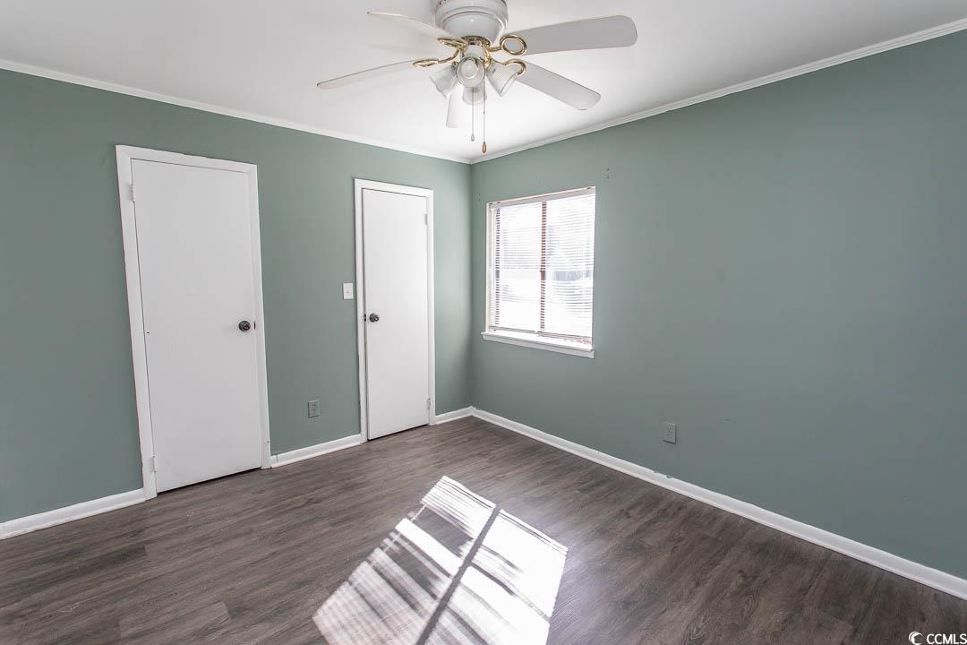950 Forestbrook Road, Unit C3 Myrtle Beach, SC 29579 - Photo 12 of 19 Unfurnished bedroom with crown molding, dark wood-style flooring, and a ceiling fan