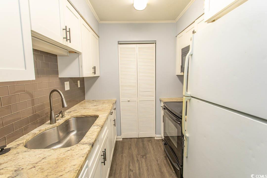 950 Forestbrook Road, Unit C3 Myrtle Beach, SC 29579 - Photo 4 of 19 Kitchen with white appliances, white cabinets, dark wood finished floors, and crown molding
